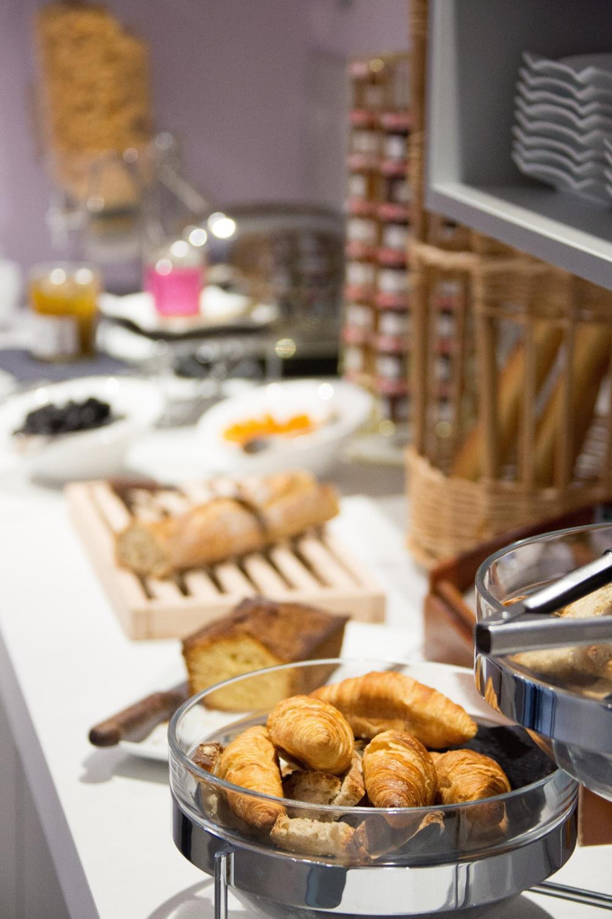 A buffet with various food items including croissants and bread.