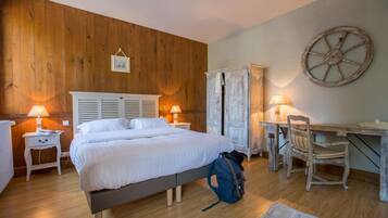 Een slaapkamer met een houten wand, een bed, een kledingkast, een bureau en een stoel.