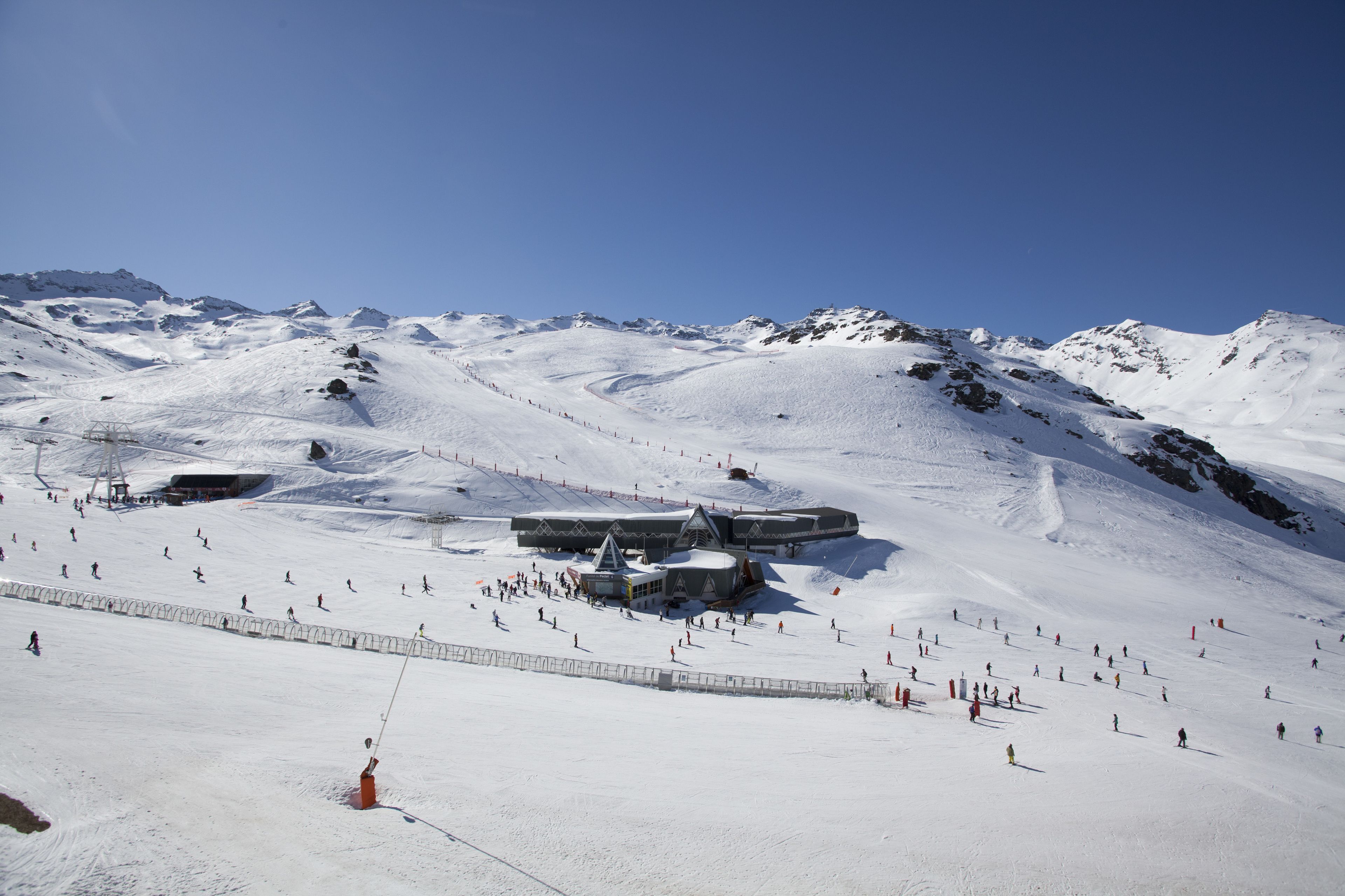 A snow-covered ski slope with a ski lift and several buildings, likely a ski resort.