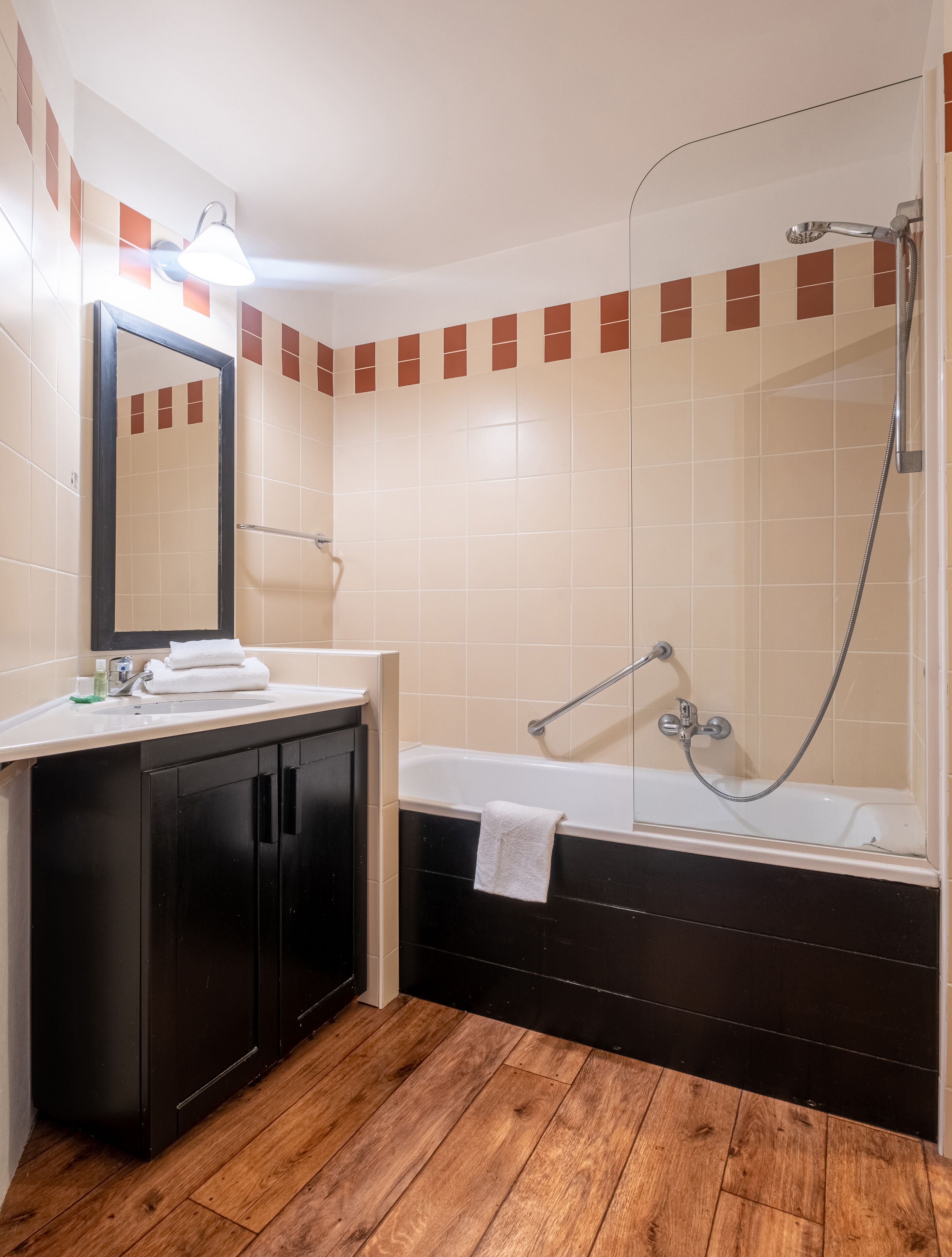 Une salle de bain avec une baignoire, un lavabo, un miroir et une douche.