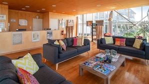 A modern lobby with two sofas, a wooden coffee table, and a reception desk.