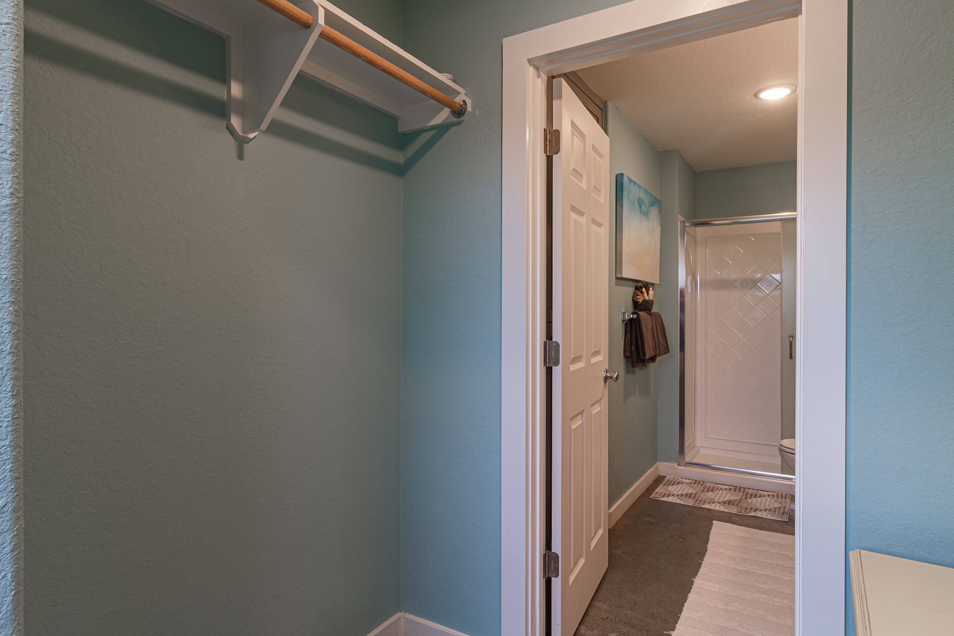 Un couloir avec une porte donnant sur une salle de bain.