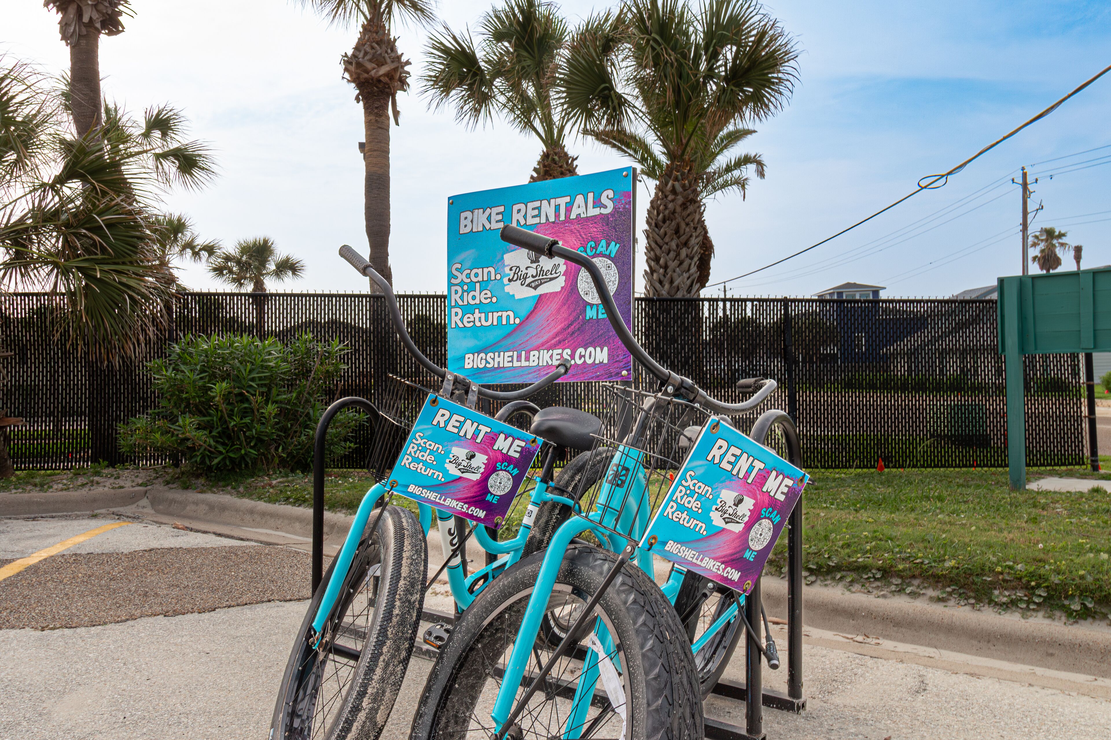 A bicycle rental station with signs advertising bike rentals and a website.