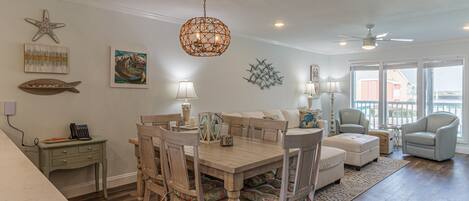 A dining area with a wooden table and chairs, a chandelier, and artwork on the walls.