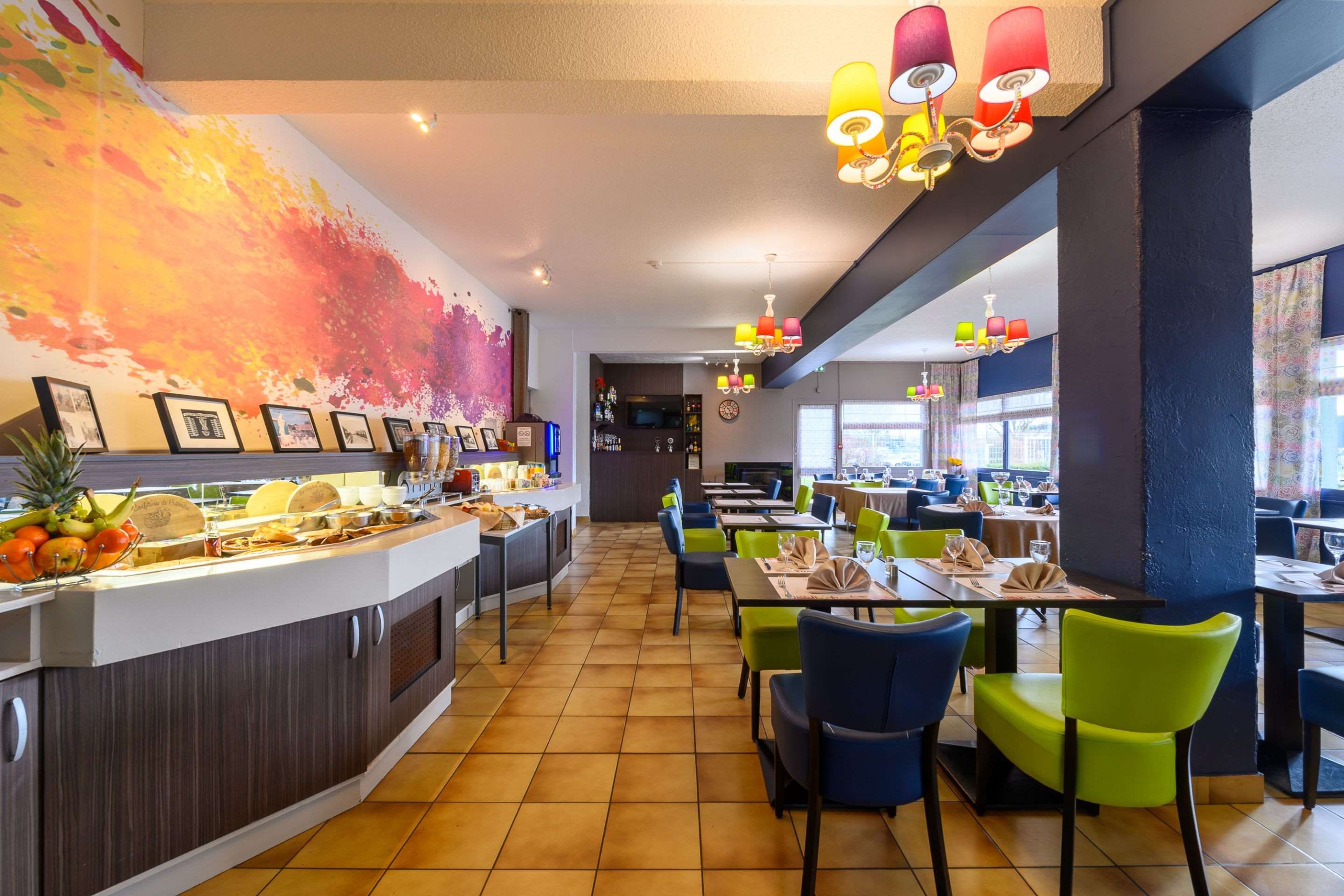 A restaurant with a buffet bar, colorful chairs, and a modern interior design.