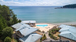 Un resort con piscina, playa y vista al océano.