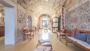Una habitación amplia con paredes de piedra, muebles de madera y un ventanal grande.