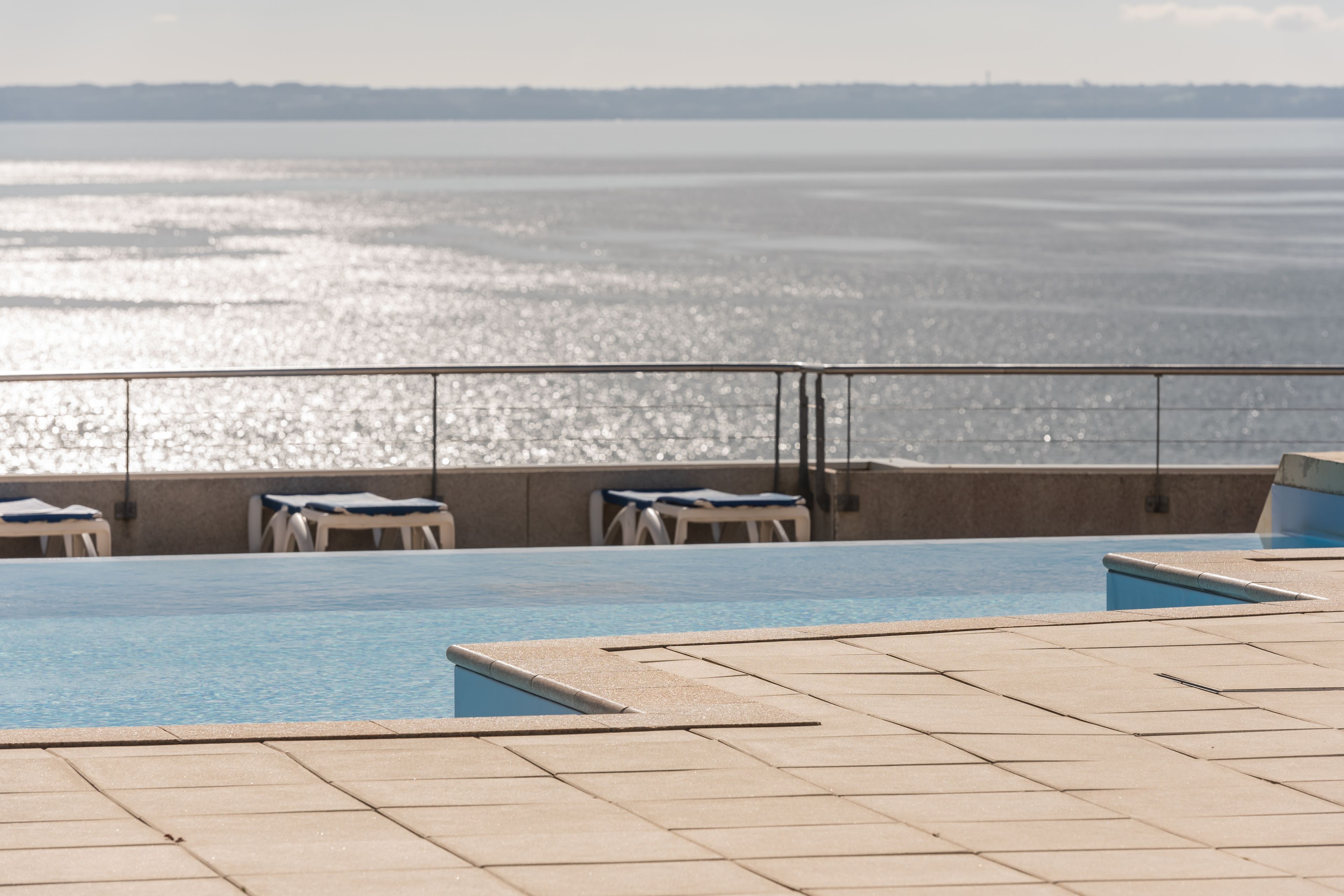 A pool area with a view of the water.