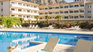 Un espace piscine avec des chaises longues, un ballon de plage et une bouée de sauvetage.