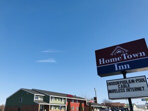A motel with a sign indicating it offers indoor pool and wireless internet.