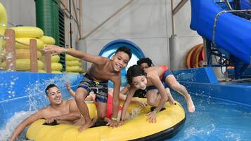 A group of people on a yellow raft in a water park.