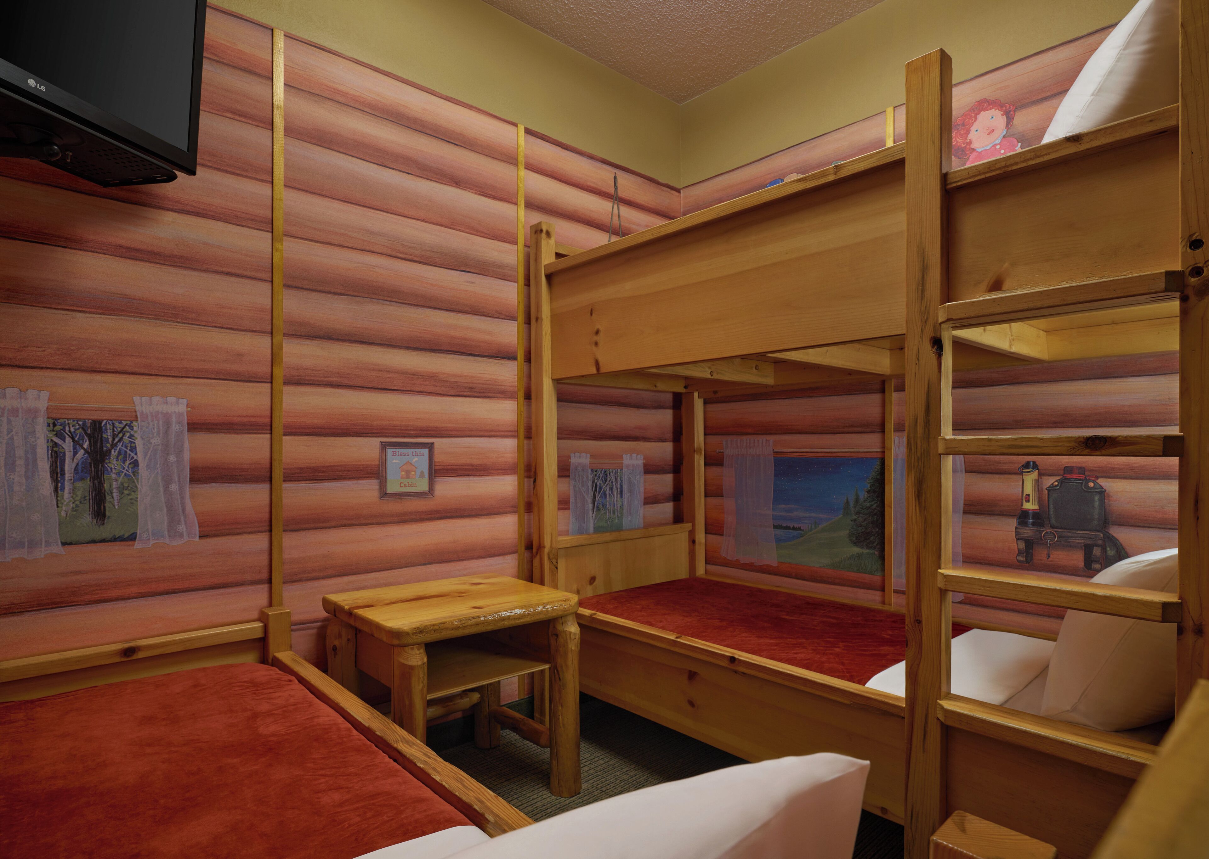 A cabin-style room with bunk beds, a television, and a small table.