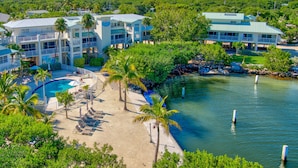 A resort with a pool, multiple buildings, and a waterfront view. - Dove Creek Resort & Marina, Trademark Collection by Wyndham (Key Largo)