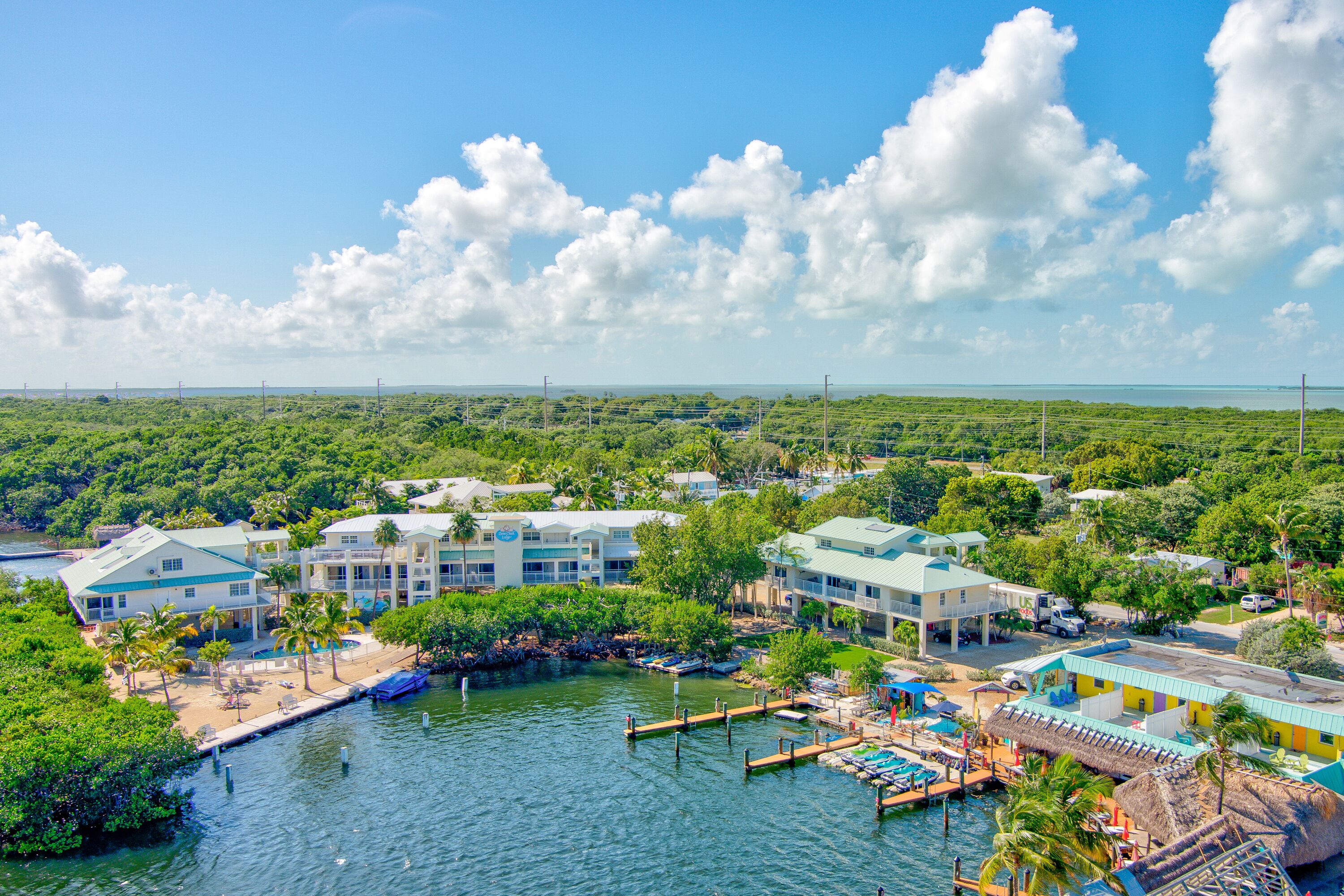 A coastal hotel with multiple buildings, a dock, and a marina.