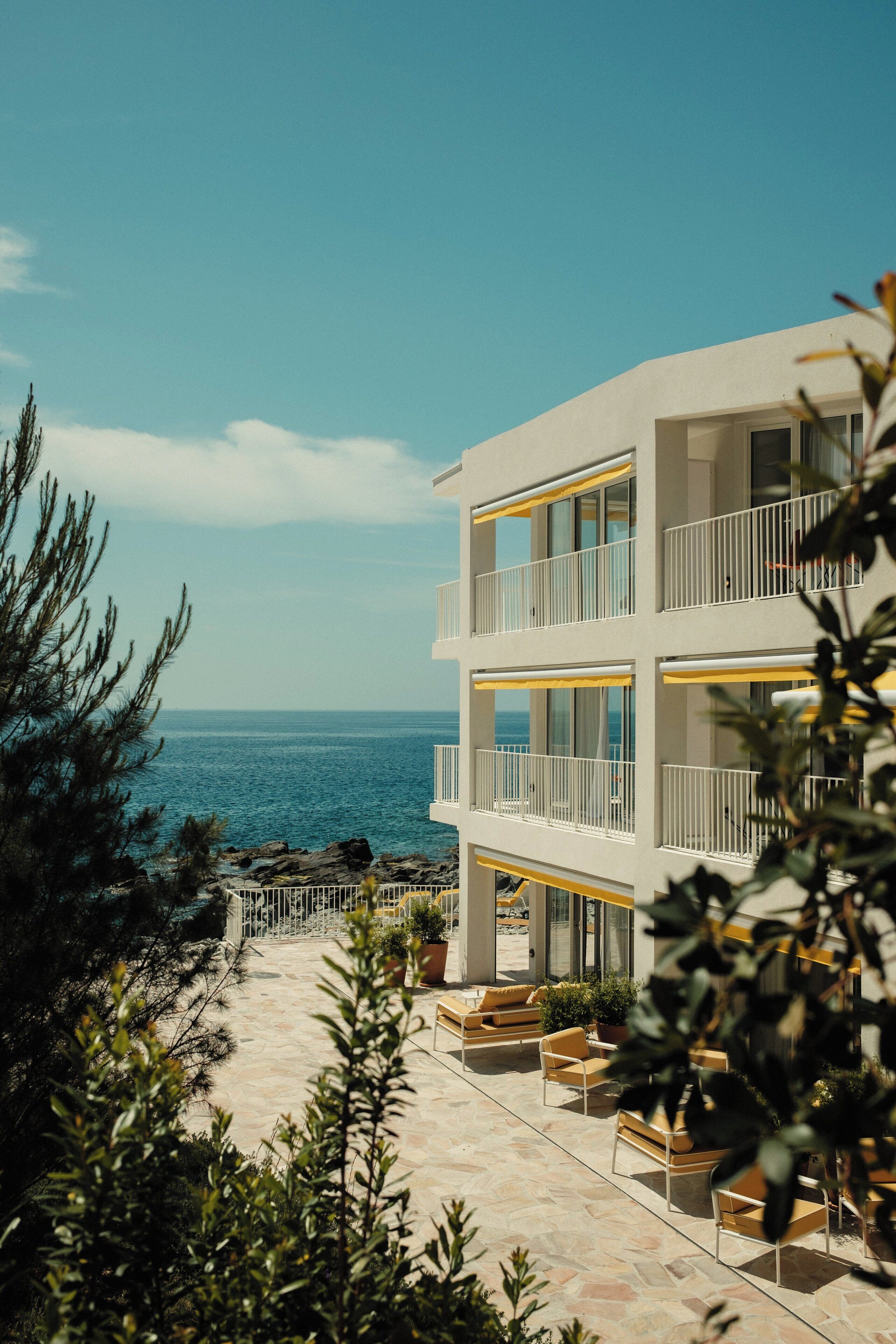 A multi-story building with balconies overlooking a coastal area.