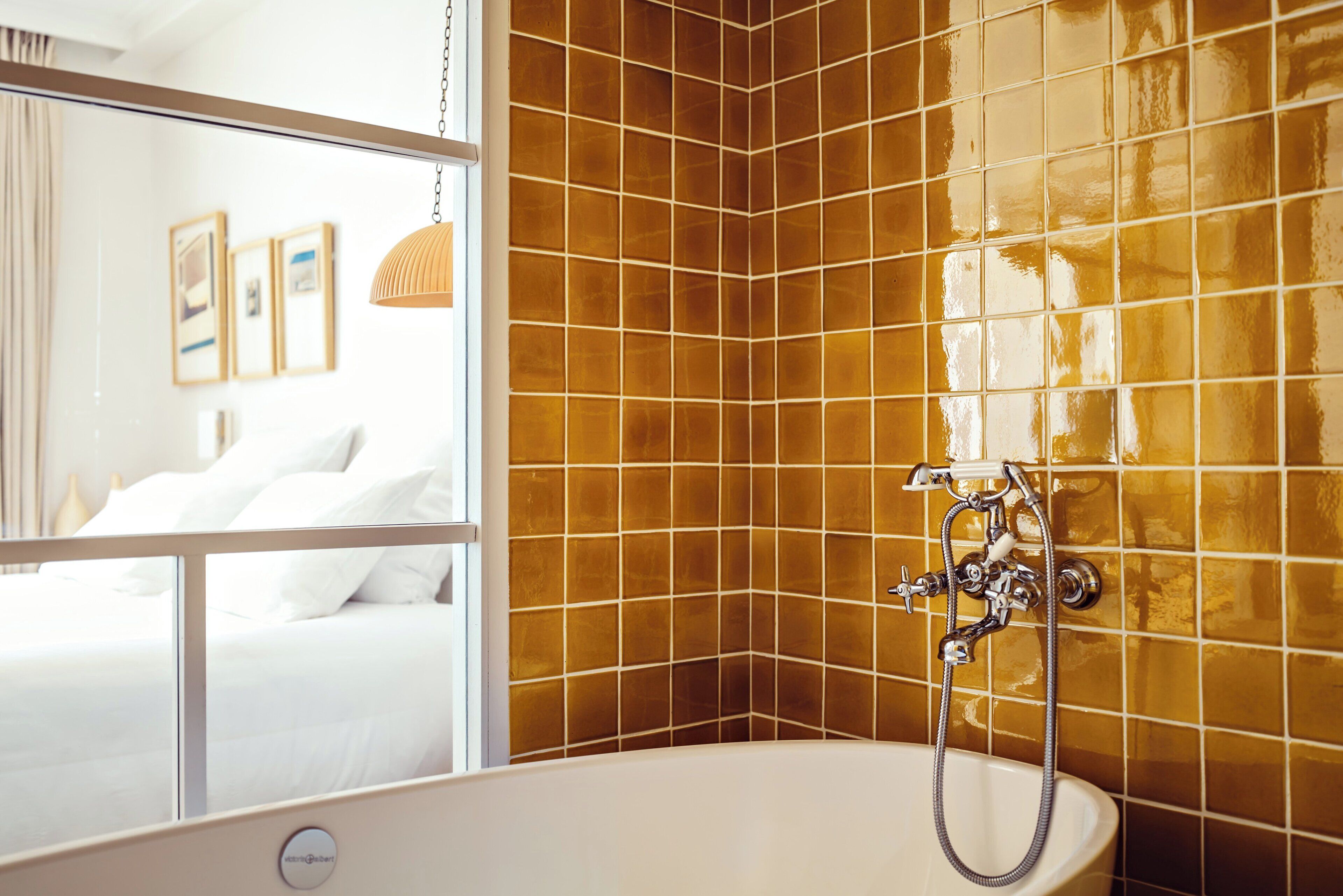 Un baño con bañera, ducha y espejo.