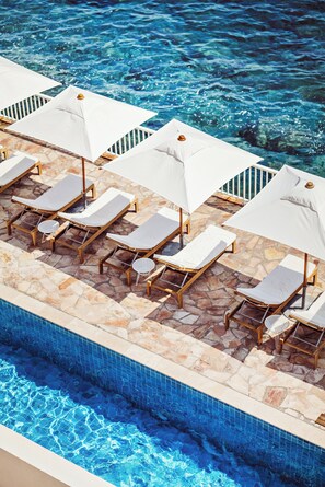 A poolside area with lounge chairs and umbrellas.