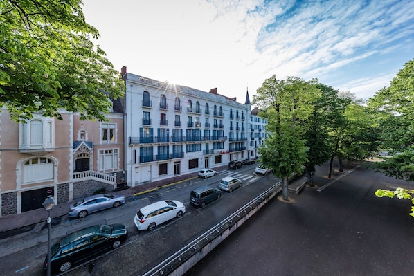 Un hotel de varios pisos con un estilo arquitectónico clásico, que cuenta con balcones y una entrada principal.