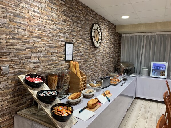 A buffet setup with various food items and a clock on the wall.