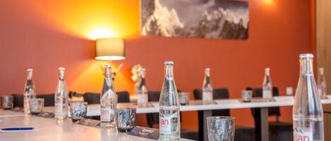 Una mesa de conferencias con botellas de agua, vasos, tarjetas de identificación y un cartel que dice 'Sowell'.