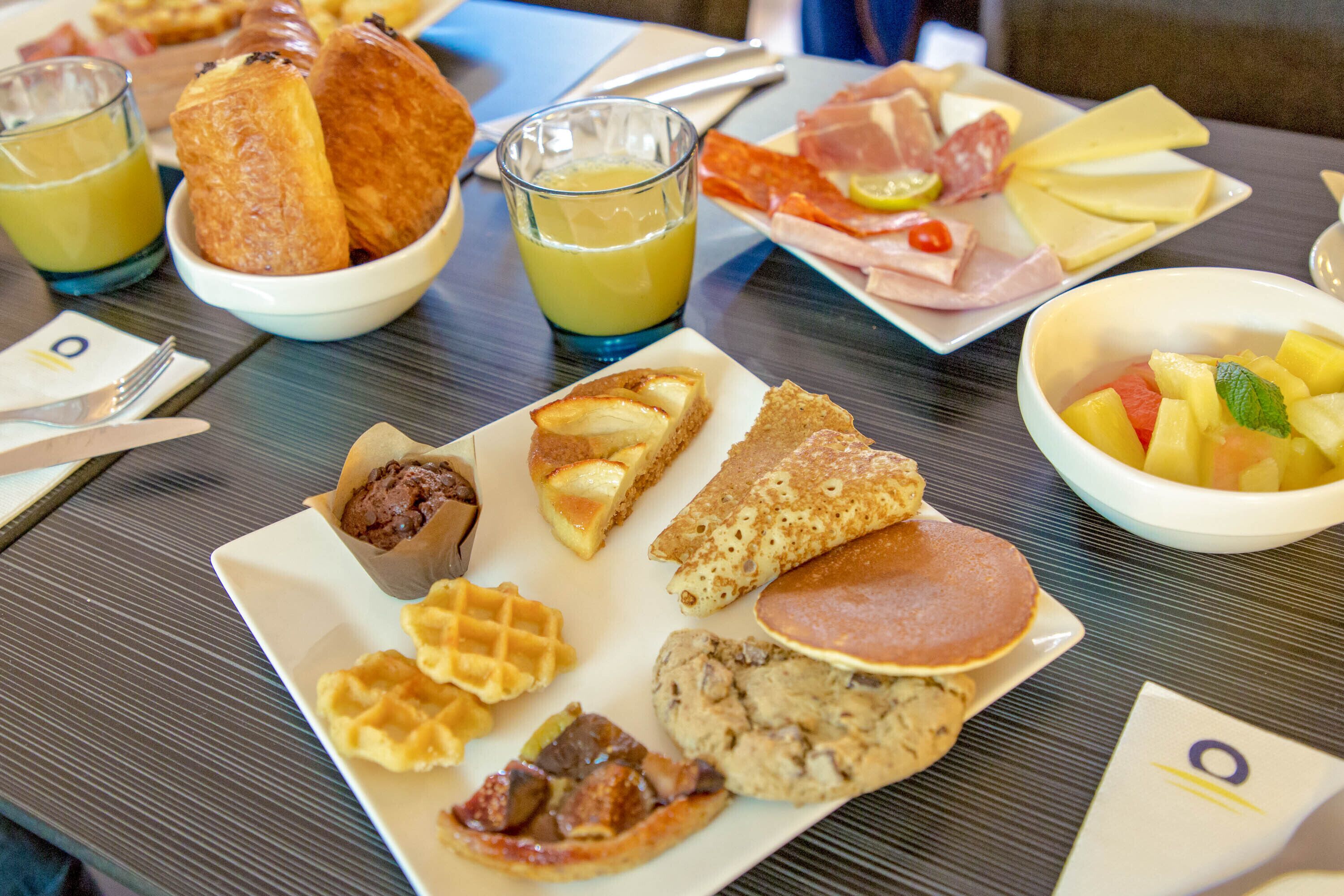 A breakfast buffet with various food items and drinks.