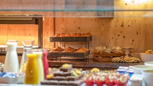 Un bufé con diversas opciones de comida, incluyendo pasteles, sándwiches y postres.