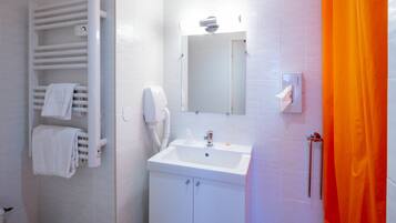 A bathroom with a white sink, a towel rack, a mirror, and an orange shower curtain.