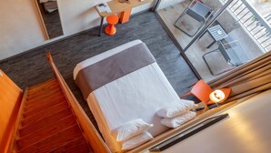 A hotel room with a bed, a desk, and a chair.