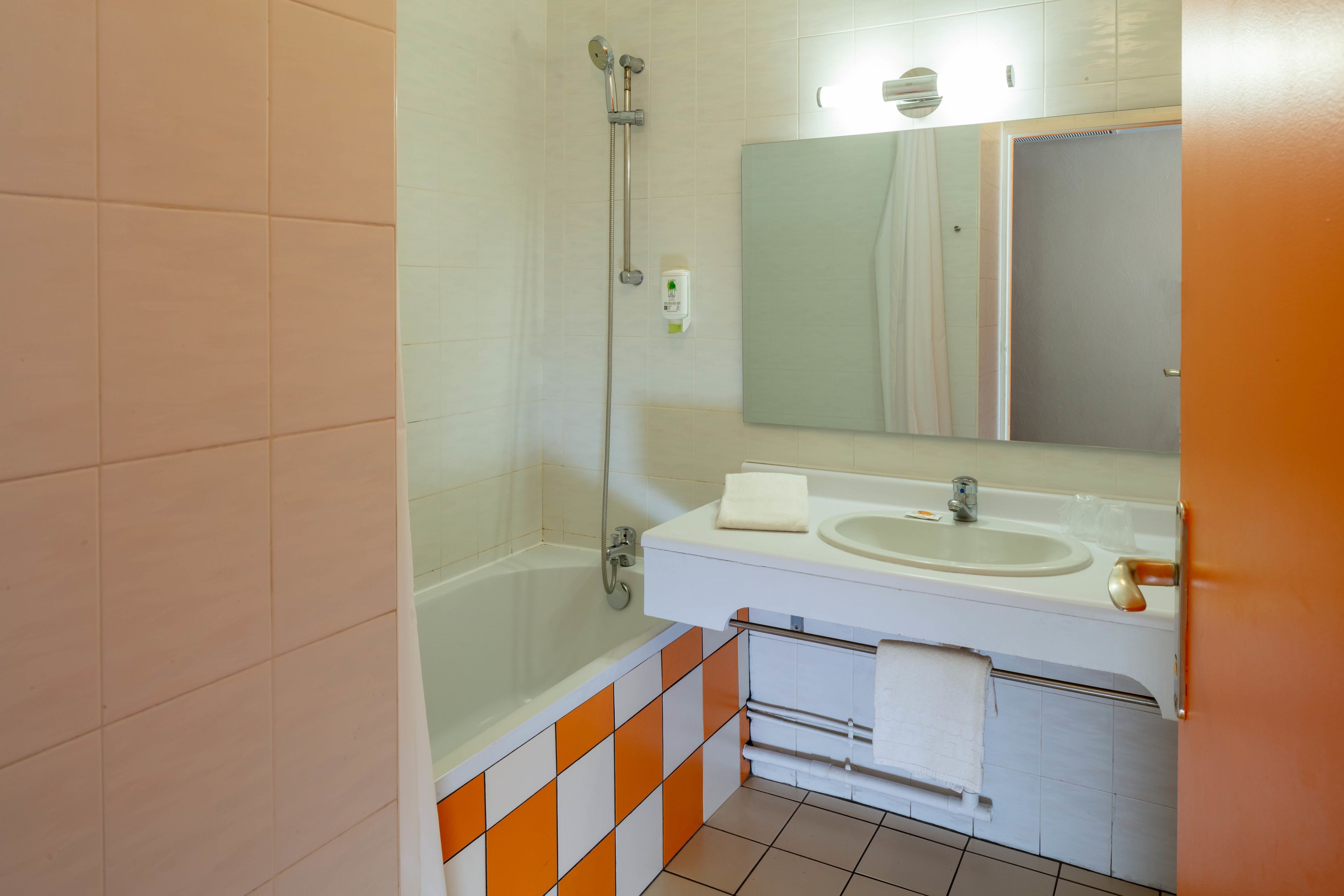 Een badkamer met een bad, een wastafel en een spiegel.