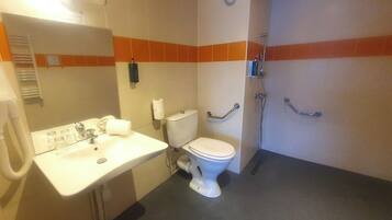 Un baño con inodoro, lavamanos y ducha.