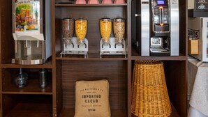 A beverage station with a coffee machine, multiple dispensers, and a wicker basket.