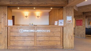 A wooden reception desk with the logo "Pierre & Vacances" and directional signs for "Terrasse" and "Parking". - Pierre & Vacances Residence L'Albane (Vars)