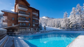 A wooden multi-story building with balconies and a swimming pool in front. - Pierre & Vacances Residence L'Albane (Vars)