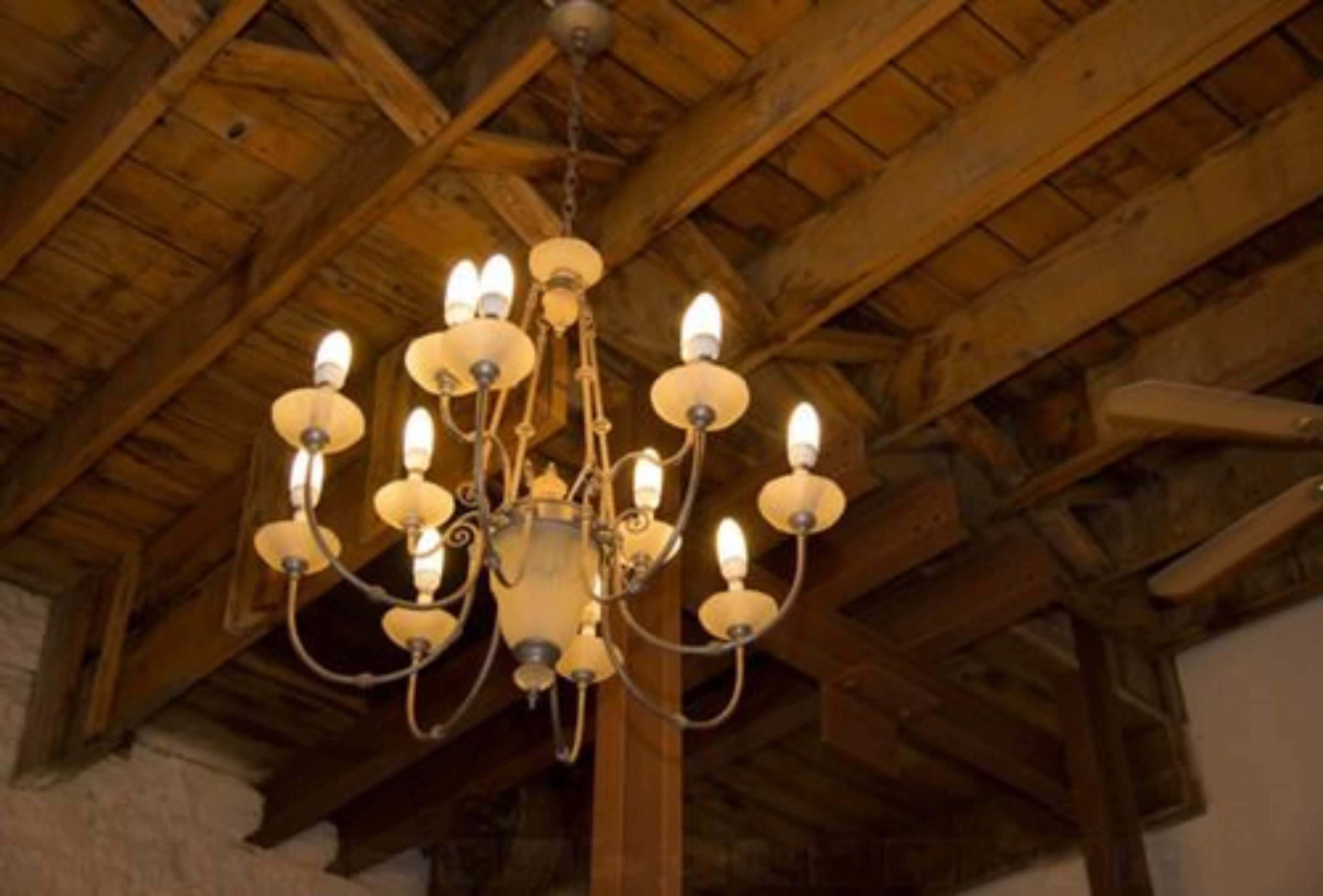 Un candelabro con múltiples brazos y lámparas colgando de un techo de madera.