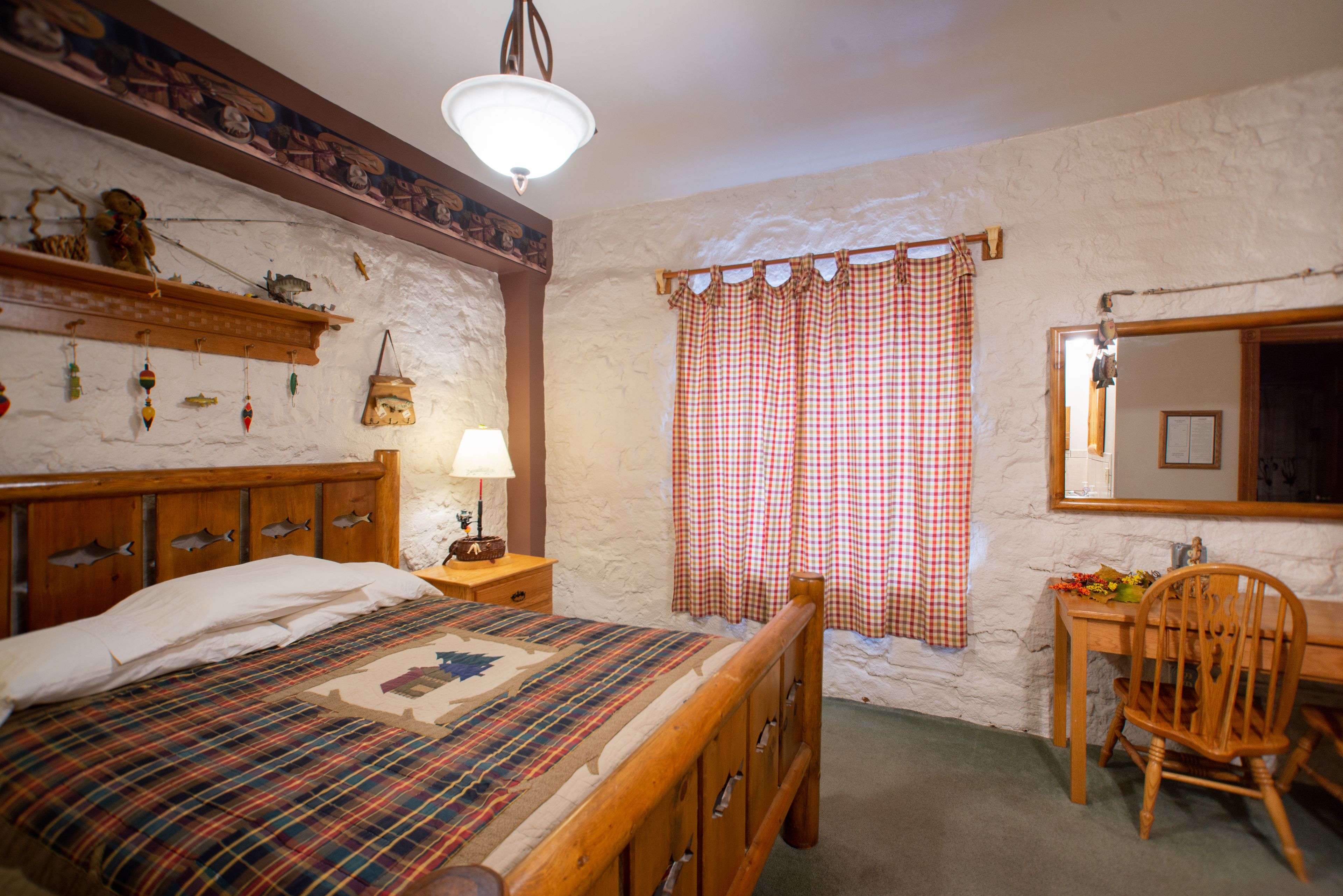 Une chambre à coucher avec un lit en bois, une table de chevet, une chaise, une commode et un miroir.