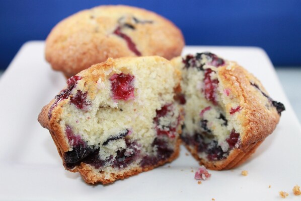 Un muffin con trozos de fruta visibles, sobre un plato blanco.