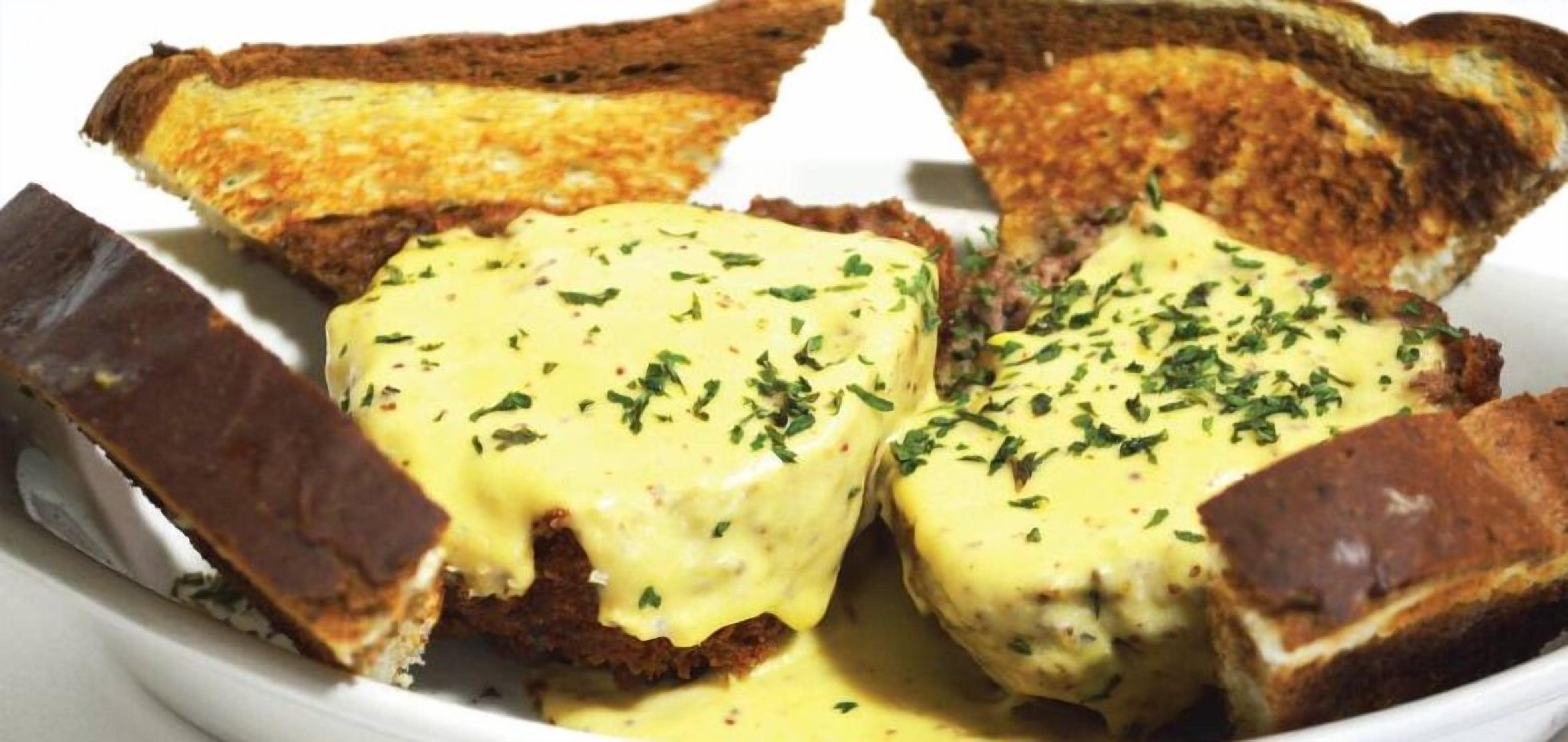 A plate of toasted bread with melted cheese and herbs.