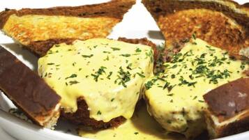 A plate of toasted bread with melted cheese and herbs.