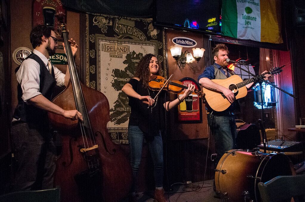 Una banda tocando en el escenario con un mapa de Irlanda al fondo.