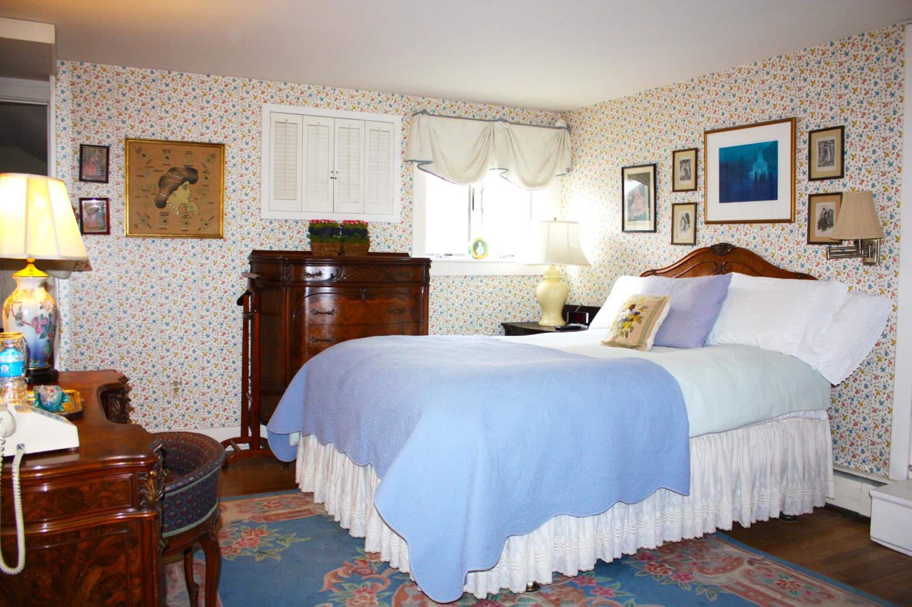 A bedroom with a bed, dresser, and desk.