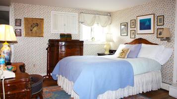 A bedroom with a bed, dresser, and desk.