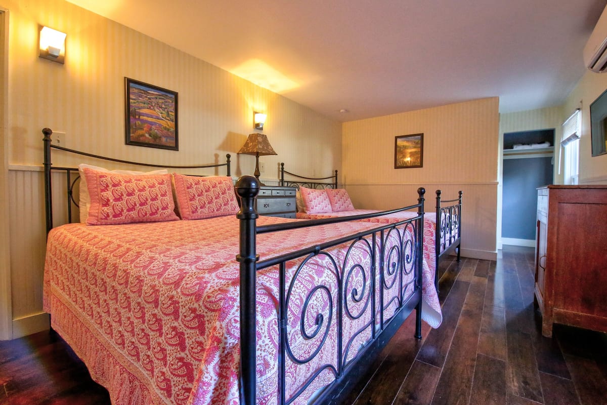 Une chambre à coucher avec un lit à baldaquin, une table de chevet, une lampe et un tableau au mur.