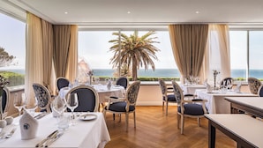 A dining area with tables set for a meal, chairs, and a view of the sea. - Longevity Senses - Cascais Boutique Hotel - Adults Only (Cascais)