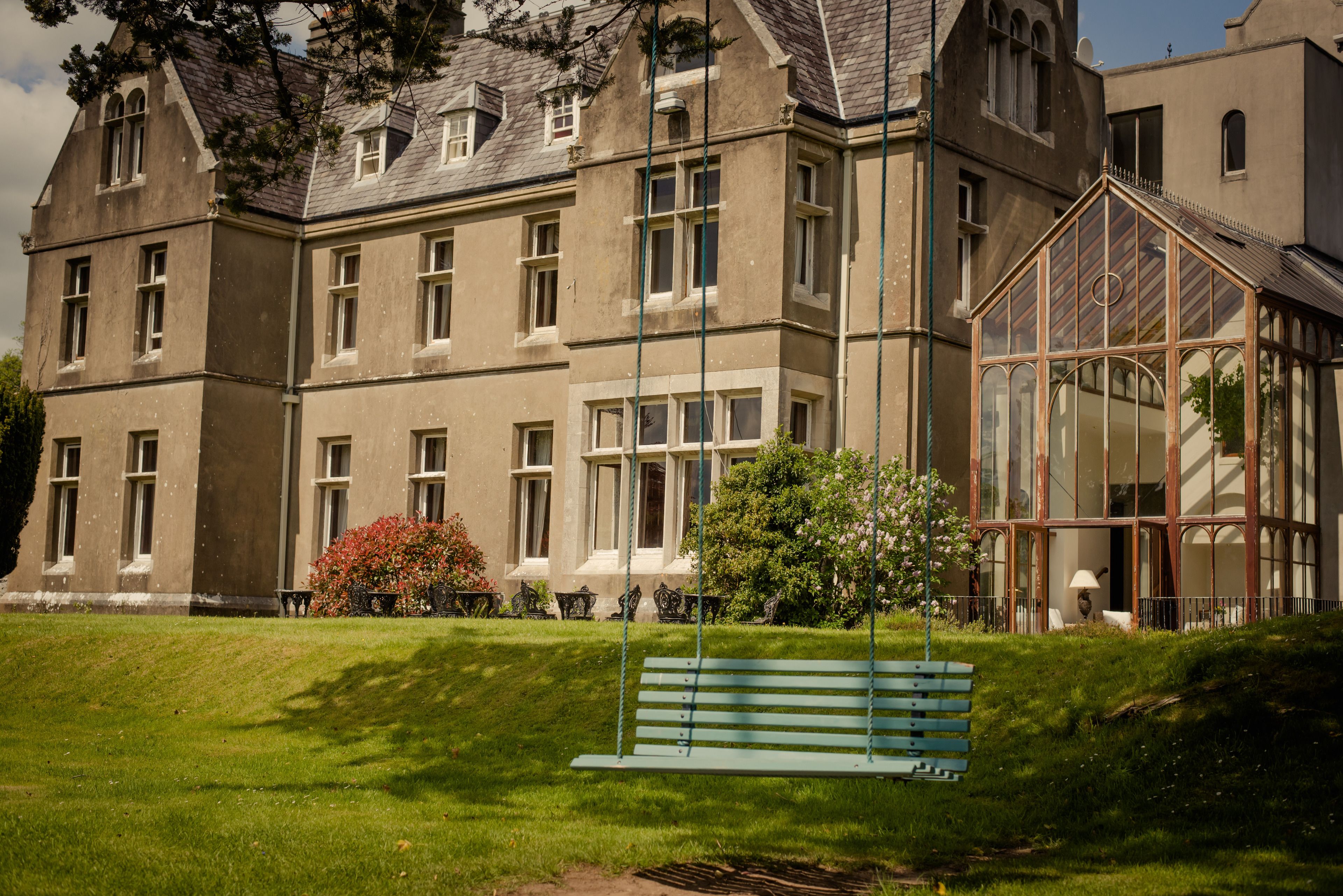 A large, historic building with multiple windows and a conservatory.