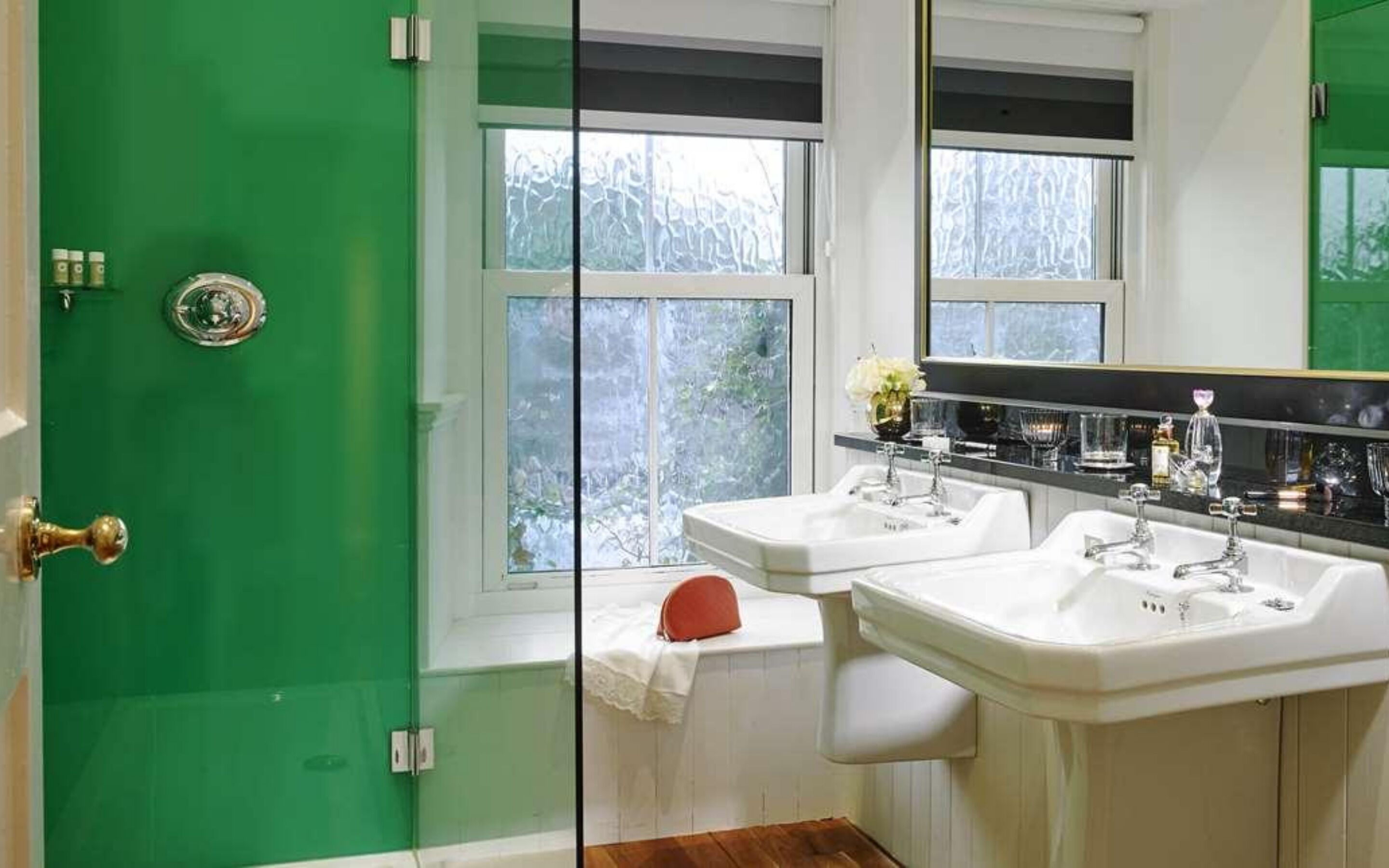 A bathroom with two sinks, a mirror, and a window.