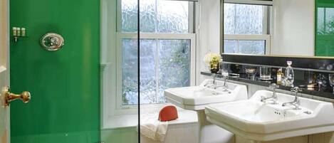 A bathroom with two sinks, a mirror, and a window.