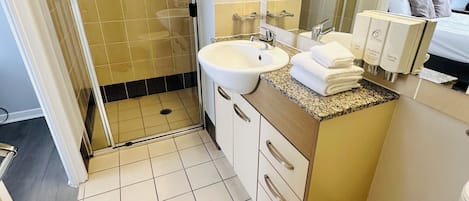 A bathroom with a sink, mirror, and toiletries.