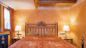 A bedroom with a large bed, two bedside tables, and a wooden ceiling.
