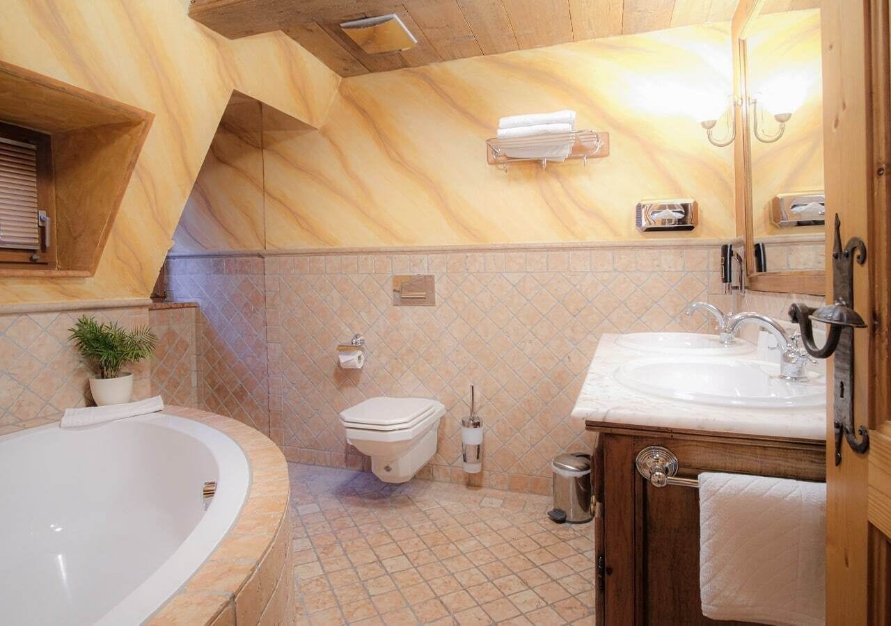 Un baño con bañera, inodoro, lavabo y espejo.