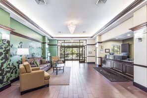 A lobby with a reception desk, a sofa, a coffee table, and a chandelier. - Sleep Inn & Suites Smithfield near I-95 (Smithfield)